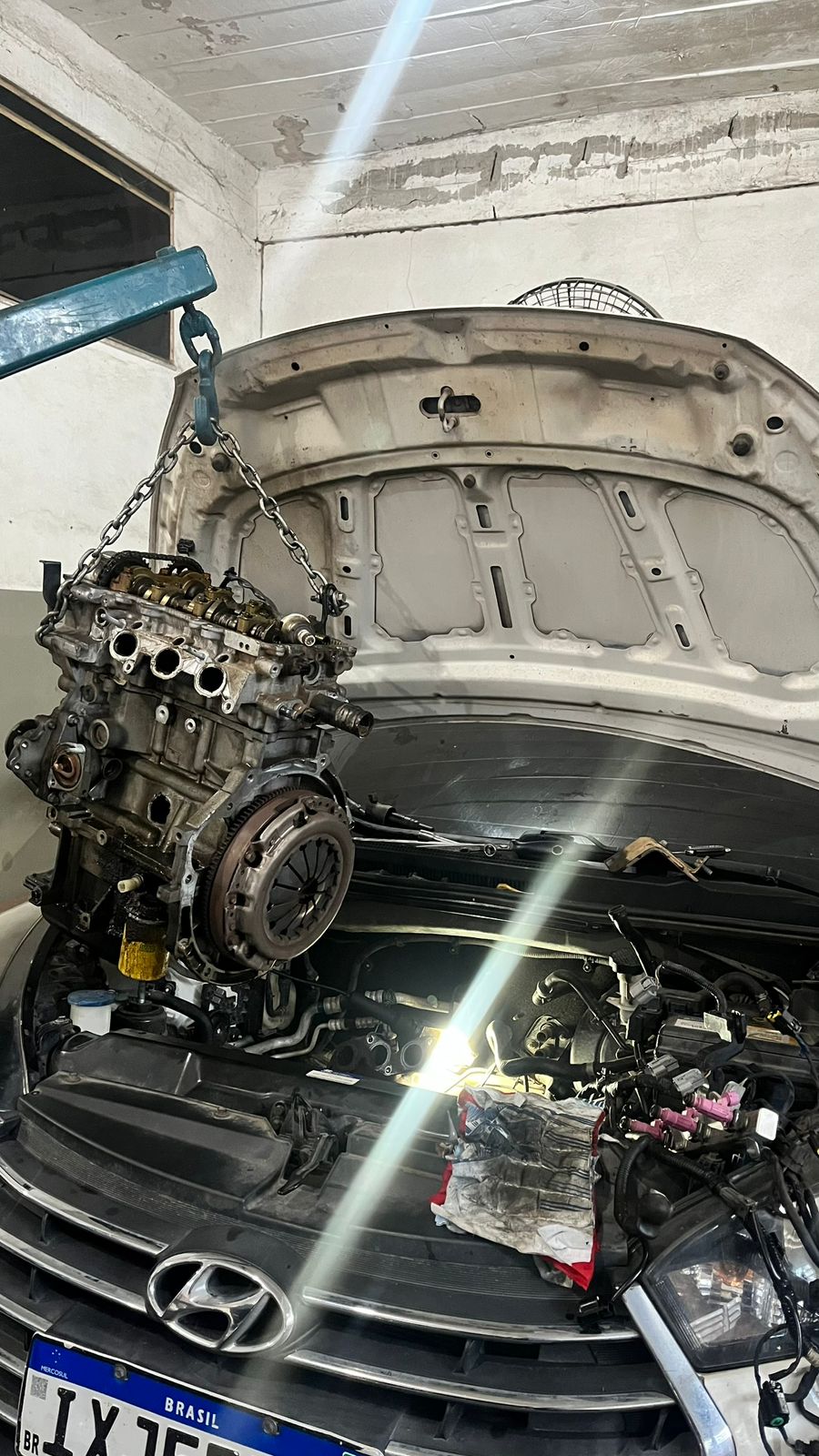 Motor sendo removido na oficina Mecânica Colombini
